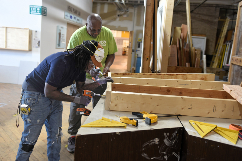 A pair of students work on building out a wooden frame at the Energy Coordinating Agency in Philadelphia on April 22. The frame will be used to help insulate the center’s own exterior walls and windows. (Kyle Bagenstose/Inside Climate News)