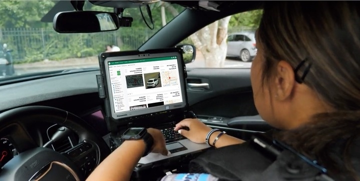 A police officer uses the Flock Safety license plate reader system.