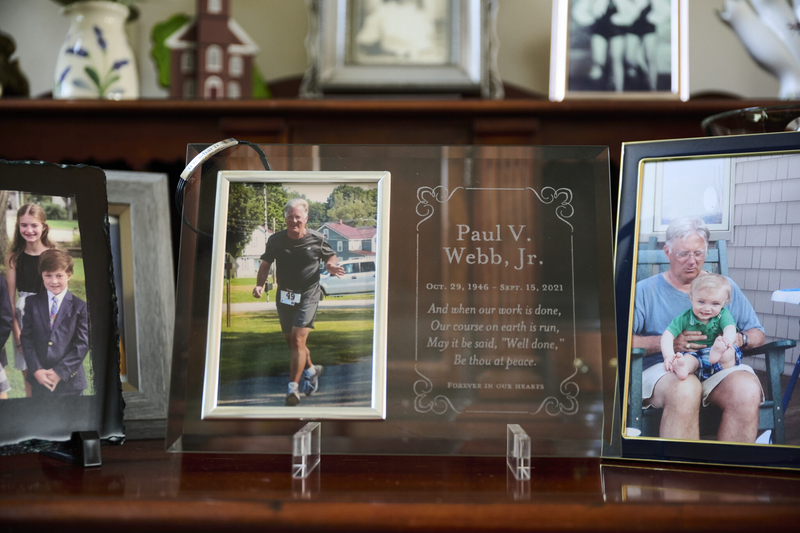 Paul Webb Jr., a 74-year-old lawyer, died a few months after developing a bedsore in an Encompass Health hospital, a lawsuit alleges. Photos of him with family members sit on a desk in his home in Mayville, New York. Encompass denied liability. (Dustin Franz for KFF Health News)
